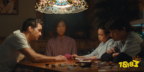 A screenshot from The Last House, a film from Netflix. A family of four sit at a table together.