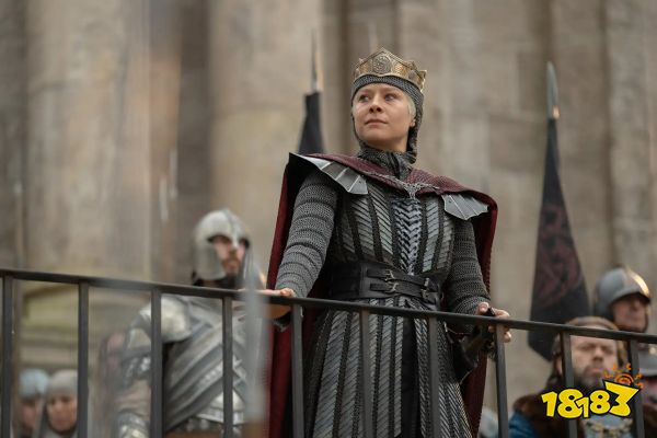 Queen Rhaenyra Targaryen (Emma D'Arcy) looks over a railing while her guards and council stand behind her in House of the Dragon