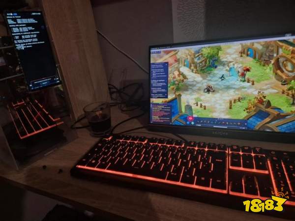 A computer setup with an Arzopa monitor displaying a colorful online role-playing game, accompanied by a backlit mechanical keyboard and a vertical screen with system information, next to a glass of dark liquid on a wooden desk.