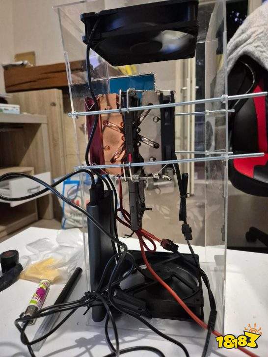 A clear acrylic case houses a vertically mounted cooling system with two large fans and various wires attached.