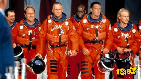(L-R) Steve Buscemi, Will Patton, Bruce Willis, Michael Clarke Duncan, Ben Affleck, and Owen Wilson in orange astronaut uniforms in Armageddon.
