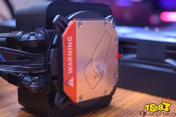 A close-up of a CPU cooler with an orange label displaying