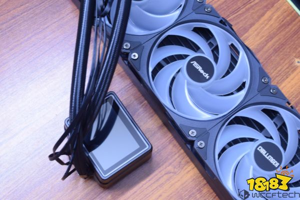 An ASRock Challenger liquid cooling system with visible fan blades and a braided cable is placed on a wooden surface.