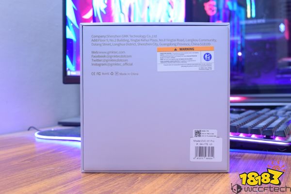 The back of a product box for the GMK EVO-X1 Pro is displayed, showing company contact information and a warning label about battery safety, with a barcode sticker indicating the model as